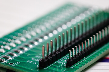 Close up on a green PCB board with two rows of interface pins.