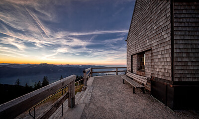 Panoramablick von einer Holzkirche auf die bayrischen Alpen bei Sonnenaufgang. Kirche auf dem...