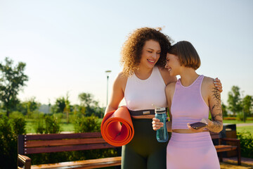 Two women share laughter and connection while relaxing outdoors.