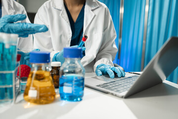 Fototapeta premium Chemist scientist holding tablet analyzing samples conducting experiment in laboratory with equipment, science concept.
