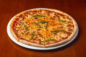 Cheese pizza on a plate on a wooden background