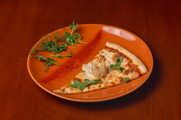 Slice of Italian pizza with shrimps on plate on wooden background