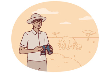 Man ranger with binoculars is watching animals in wild being in national reserve with hippos. Guy tourist in hat went on safari trip to africa to explore environment of promise of wild animals