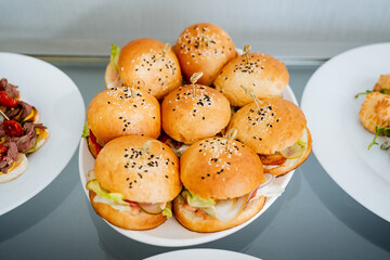 An incredibly tempting array of mouthwateringly delicious hamburgers is beautifully arranged on a plate, eagerly waiting for anyone with a passion for this beloved dish to indulge