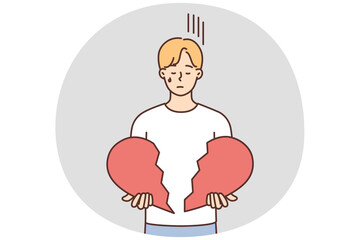 Unhappy man hold broken heart in hands