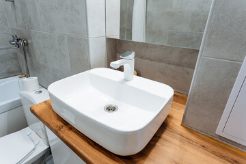 A standard bathroom design typically incorporates essential fixtures such as a sink, a toilet, and a mirror placed conveniently above the sink to enhance both convenience and functionality