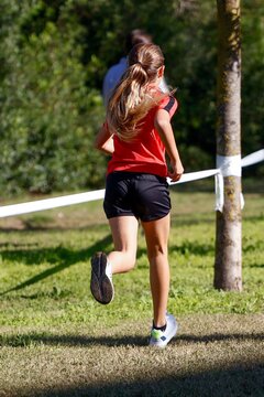 Young Female Runner in Red Shirt During Cross-Country Race in Sant Cugat del Vall&egrave;s, Spain