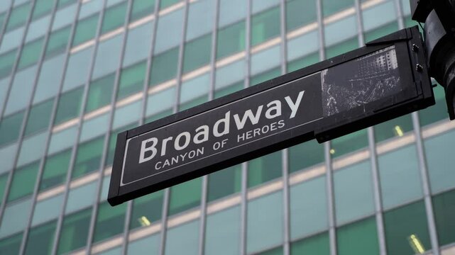 Broadway Canyon of Heroes street sign in a vibrant urban setting