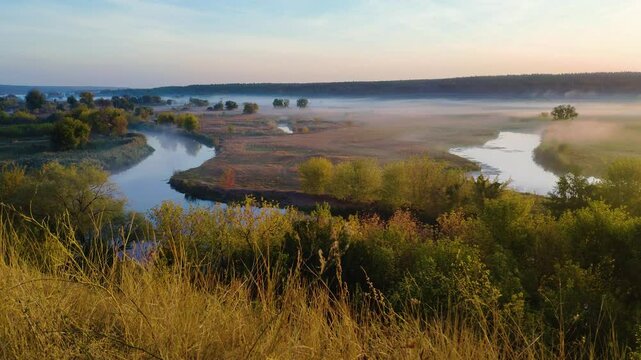 Autumn picturesque landscape with morning fog over the valley with trees along the river banks. River Seversky Donets (Siversky Donets) in the countryside