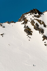 High angle view of a snowy mountainside where a splitboarder has descended on his splitboard