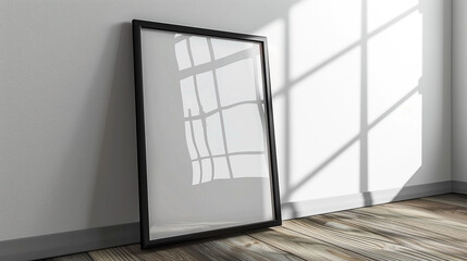 a black framed poster mockup leaning against the wall on wooden floor with window reflections