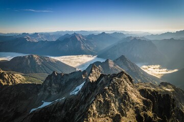 Aerial view of mountain peaks and misty valleys.