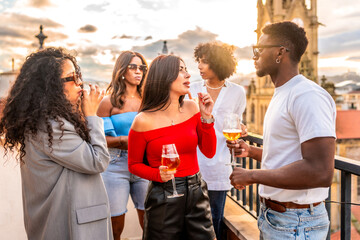 Multi-ethnic people celebrating evening party on rooftop