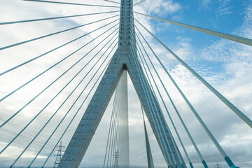 A modern cable-stayed bridge against a cloudy sky showcasing its architectural design in an urban landscape during daylight