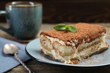 Piece of tasty tiramisu on wooden table, closeup