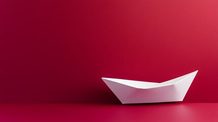Fototapeta premium White paper boat on a red background.
