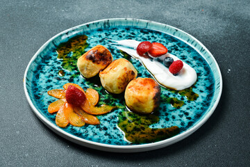 Cheese pancakes with strawberries and sour cream. On a plate. Breakfast.
