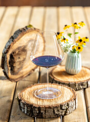 glass of red wine on a wooden trunk