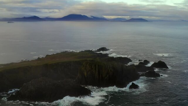 Aerial static shot of moody Malin Head with fog and Donegal mountains in the backdrop