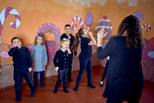 5-7 year old children at an acting class with their teacher, extracurricular activities