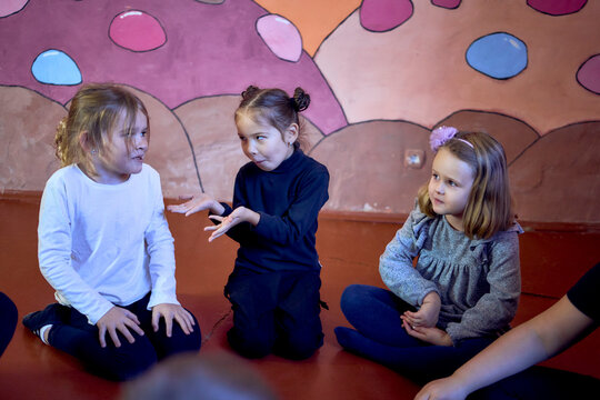 5-7 year old children sit in a circle at an acting class, extracurricular activities