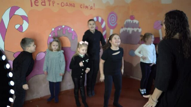  5-7 year old children at an acting class with their teacher, extracurricular activities