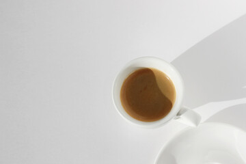 Cup of Espresso Coffee with Crema Foam on White Table Background. Coffee Drinking.