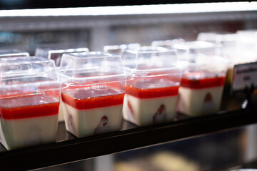 Cakes and sweets on the front of a small coffee shop, bokeh light background