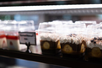 Cakes and sweets on the front of a small coffee shop, bokeh light background