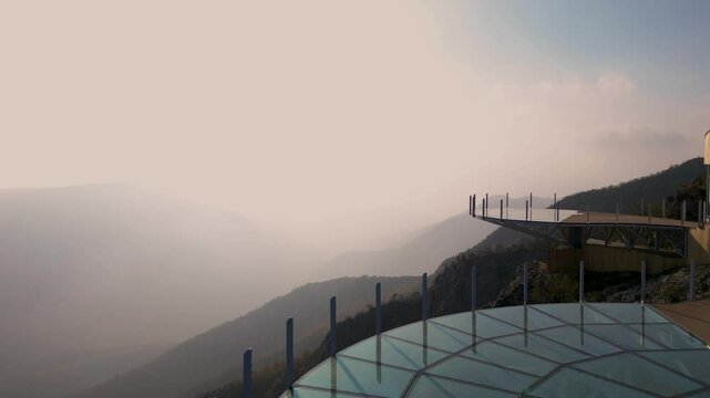 Aerial scenic view of modern and futuristic glass skywalk viewpoint, extending over mountain Ovcar and Kablar canyon in Serbia. Meanders of West Morava river. Ovcarsko-Kablarska gorge.