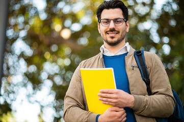 Male student outdoor smiling in a college park