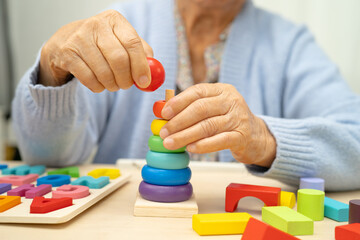 Alzheimer disease AD, Asian elderly woman patient suffering from dementia learn practical motor...