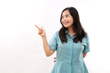 Happy Asian girl indicates at empty space for sale logo smiles positively shows something pleasant grins at camera dressed in casual shirt. Look at this promo deal. Check out this good offer