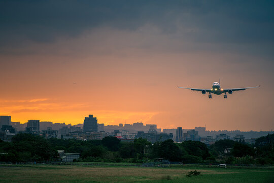 Airplane landing at sunset at Songshan International Airport in Taipei