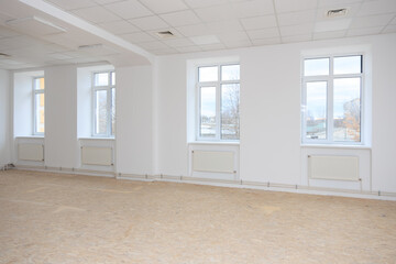 Fototapeta premium Spacious renovated room with large windows and white walls, natural light filling the space