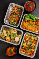 Delicious gourmet meal set in foil containers with salad and soup, ideal for catering or delivery