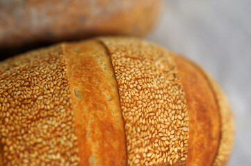 Closeup photo of crust with sesame seeds of home baked bread