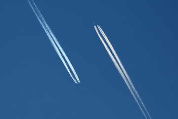 Airplanes in the blue sky with contrails. Shallow depth of field.
