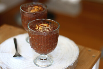 Two bowls of chia seed, chocolate and orange pudding. Healthy snack, wooden background. Selective focus.