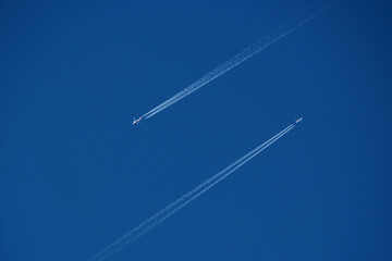Airplanes in the blue sky with contrails. Shallow depth of field.
