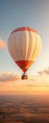 Fototapeta premium A colorful hot air balloon soars in the sky at sunset, surrounded by expansive landscapes, creating a serene and picturesque scene.