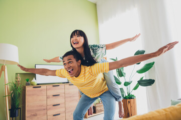 Photo of good mood cheerful multinational couple wife and husband enjoy weekend together piggyback...