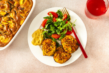 Enjoy a delicious and healthy breakfast with zucchini pancakes, fresh lettuce, and tomatoes, complemented by cherry compote and a slice of peach pie for a flavorful start to your day
