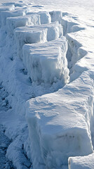 A close-up view of an ice shelf with cracks running through it, revealing the blue ice beneath.