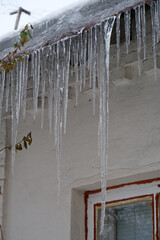 Large long icicles hang from roof of house