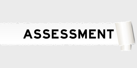 Ripped gray paper background that have word assessment under torn part