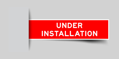Red color square label sticker with word under installation that inserted in gray background