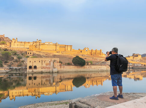 Tourist backpack man taking a picture of Amber fort or Amer great palace in the morning , Jaipur, Rajasthan, India