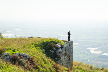 Obraz premium A man stands at the edge of a cliff