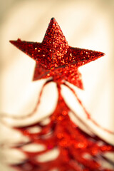 Glittering red star decoration atop a festive Christmas tree during the holidays